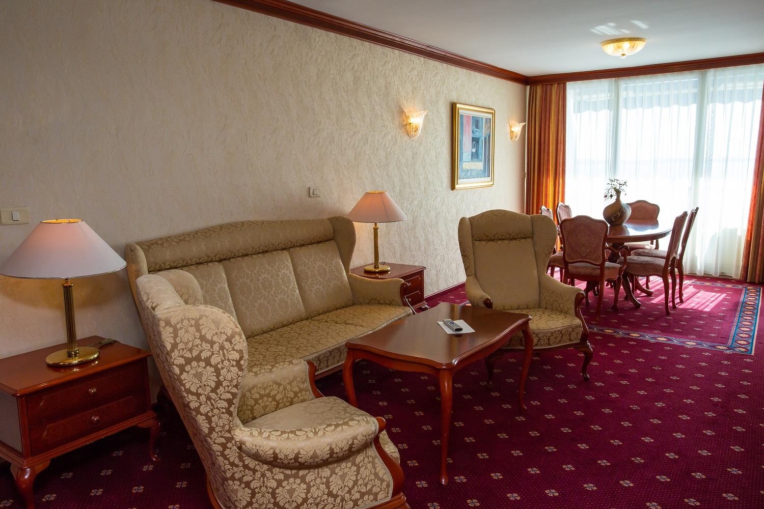 Grand Hotel Bernardin Portorose Esterno foto The photo shows a cozy living area that features a set of elegant furniture. There is a comfortable sofa with a light floral pattern, accompanied by two armchairs in a matching style. A wooden coffee table sits in the center, and there are decorative