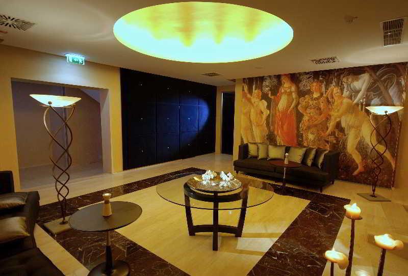 Grand Hotel Bernardin Portorose Esterno foto The photo depicts an elegantly designed interior space, likely a lobby or lounge area. It features a modern aesthetic with a large, round ceiling light that emits a warm glow. The flooring is a combination of light and dark materials, creating a styl